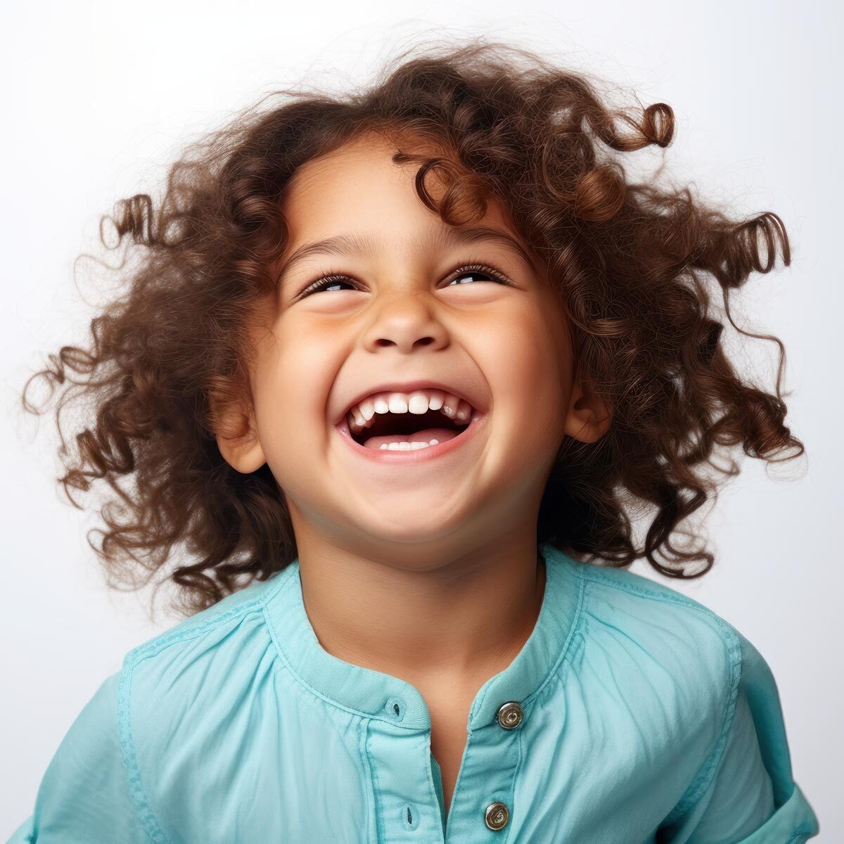 A joyful young girl with curly hair bursts into laughter, radiating happiness and positivity.